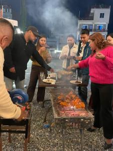 a group of people standing around a grill with food at Universal Bliss in Pokhara