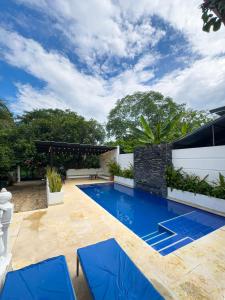 einen Pool im Hinterhof mit blauen Stühlen in der Unterkunft Villa Clara Casa Campestre, Piscina, Naturaleza, Paseo de Río in Melgar