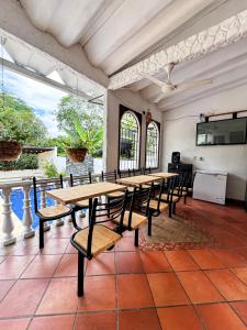 ein Esszimmer mit Tisch und Stühlen und einem Fernseher in der Unterkunft Villa Clara Casa Campestre, Piscina, Naturaleza, Paseo de Río in Melgar