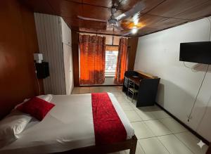 a bedroom with a bed and a window and a desk at Hospedaje Casa Amazónica Iquitos in Iquitos