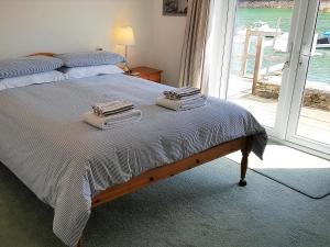 a bedroom with a bed with two towels on it at Tarquins in Fowey +10 photos
