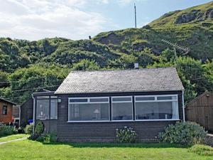 una pequeña casa frente a una montaña en Braemar, en Lendalfoot