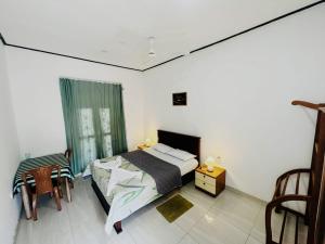 a bedroom with a bed and a table and chairs at Viyan hotel in Negombo
