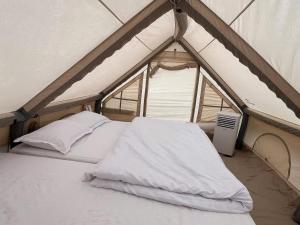 a white bed in a tent with a window at Hương Lúa Homestay Măng Đen in Kon Plong