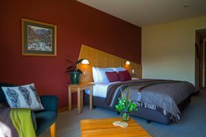 a hotel room with a bed and a couch at Wilderness Lodge Arthurs Pass in Arthur's Pass
