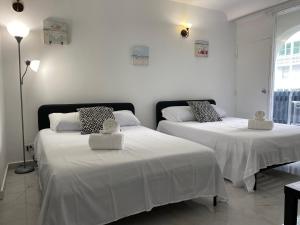 two beds with white sheets in a room at Condado Serenity by the Sea in San Juan