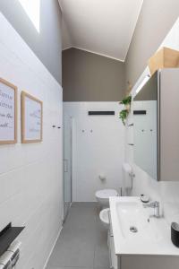 a white bathroom with a sink and a toilet at Houses and Apts. in Albarella 24882 in Palazzo Vianello