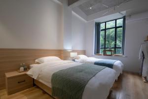 a bedroom with two beds and a window at Sheng Hai Yun Ju in Zhuhai