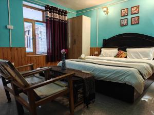 a bedroom with a large bed and a table and chairs at Nirvana River Nest in Sainj +12 photos