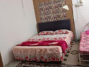 a bedroom with a bed with a red comforter at Roomstay Ummi in Macang +9 photos