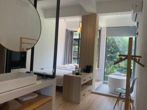a bathroom with a sink and a tub and a mirror at Sheng Hai Yun Ju in Zhuhai