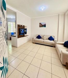 a living room with two couches and a tv at León Dormido Suite 01 in Puerto Baquerizo Moreno