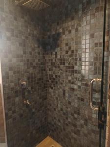 a bathroom with a shower with a tiled wall at The windsor Retreat in Moratuwa