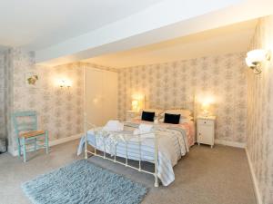a bedroom with a bed and a blue rug at Greenlands Farmhouse in Barmby on the Moor