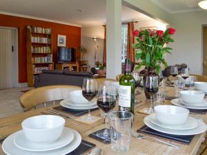 a table with wine glasses and a bottle of wine at Holly Cottage in Pett
