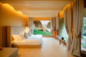 a bedroom with a bed and a large window at Lazula in Ban Pok Nai