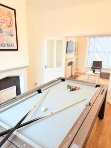 a pool table in a living room with a fireplace at 4 bedrooms 8 beds Wi-FI smart tv games room in Hull