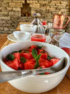 a bowl of strawberries with a spoon in it on a table at Buransh Retreat in Jageshwar +43 photos
