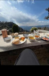 a table topped with plates of food on a table at Buransh Retreat in Jageshwar