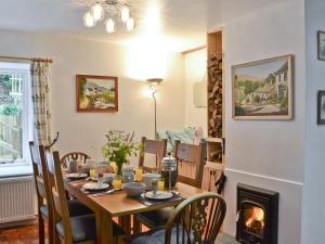 a dining room with a table and a fireplace at Burrills View in Horderley