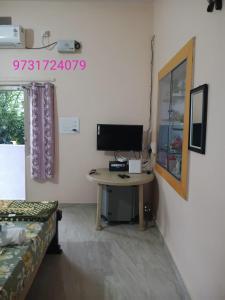 a room with a desk with a computer on it at Manvitha Homestay in New Hampi