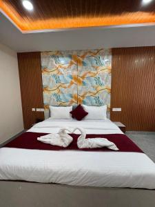 a bedroom with a bed with two white towels on it at The Vizata Hotel in Jaipur +2 photos