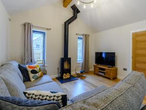 a living room with a couch and a wood stove at Rinstone Lodge in Thornton Dale