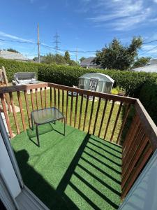 a deck with a bench and a chair on it at Chambre à louer proche de Montréal in Sainte-Catherine