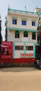 a building with a coca cola sign in front of it at Sarat guest house in Digha