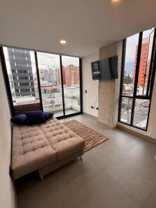 キトにあるSuite modernaのソファとテレビのある広いリビングルーム +6枚の写真