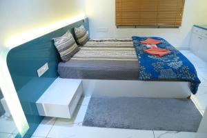 a bed in a room next to a window at The Crownstone Apartment in Trivandrum