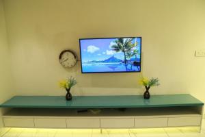 a flat screen tv hanging on a wall with a shelf at The Crownstone Apartment in Trivandrum