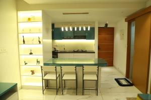 a kitchen with a table and chairs in a room at The Crownstone Apartment in Trivandrum