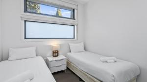 アポロ・ベイにあるTriplet Apollo Bayの窓のある小さな部屋にベッドが2つある