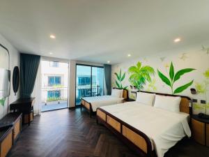 a hotel room with two beds and a balcony at The Green Hotel Vientiane in Vientiane