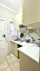 Una cocina con gabinetes blancos y una encimera blanca. en Seaside Studio 22, en East London