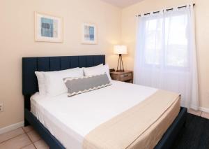 ein Schlafzimmer mit großem Bett und Fenster in der Unterkunft Oceanview Cottage Walk to Beach & Restaurants in Enighed