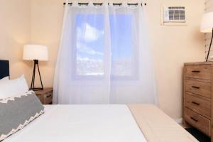 ein Schlafzimmer mit einem weißen Bett und einem Fenster in der Unterkunft Oceanview Cottage Walk to Beach & Restaurants in Enighed + 21 Fotos