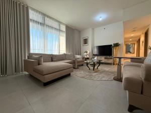 Una sala de estar con un sofá y un televisor. en Luxury 2-Bedroom APT - Sea Views in Saadiyat Island, en Abu Dabi