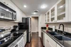 a kitchen with white cabinets and a black refrigerator at Stylish 2BD Condo Pool Grand Prairie GP66B in Heliport-Facility 5A