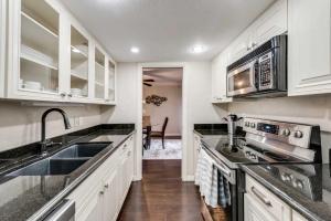 a kitchen with white cabinets and a sink at Stylish 2BD Condo Pool Grand Prairie GP66B in Heliport-Facility 5A