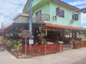 a store with plants in front of a building at Ning Ning hostel Dondet in Don Det