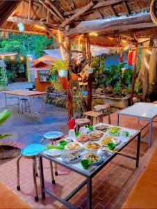 a table with plates of food on it at Huy Hoàng Homestay Kiên Giang in Lai Sơn
