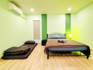 a bedroom with a bed in a room with green walls at Palm Garden house 1 close to Bang Tao beach in Ban Phak Chit