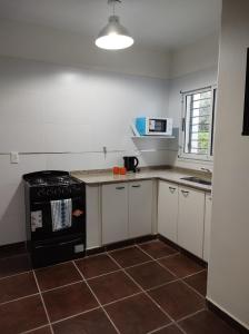 a kitchen with a black stove and a microwave at Cabañas El Ceibo in Villa la Bolsa
