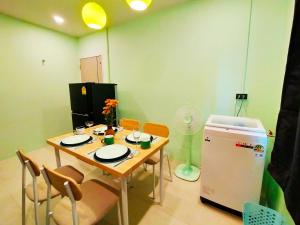 a dining room with a table and a refrigerator at Palm Garden house 1 close to Bang Tao beach in Ban Phak Chit