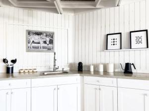 a white kitchen with a sink and a picture of a horse at Luxury Oceanview Villa Walk to Beach & Dining in Enighed