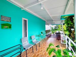a room with chairs and a blue wall at Palm Garden house 1 close to Bang Tao beach in Ban Phak Chit