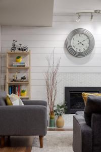 sala de estar con reloj en la pared en Coho Trailside Comforts, en Brackendale