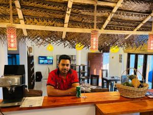 a man sitting at a bar in a restaurant at The Lotus House - Ahangama in Ahangama
